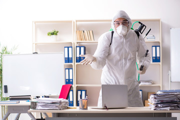 Professional contractor doing pest control at office 