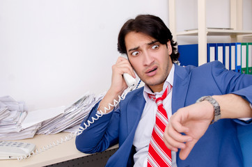 Young businessman employee unhappy with excessive work 