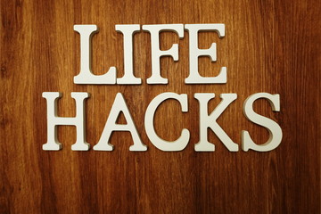 Life Hacks word alphabet letters on wooden background