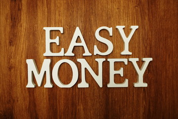 Easy Money word alphabet letters on wooden background