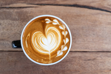 Hot art coffee cappuccino in a cup on wooden table background  with copy space
