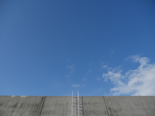 Concrete wall and white ladder	