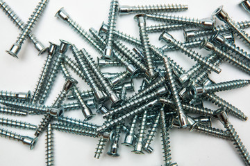 Mound of furniture screws top view on white background