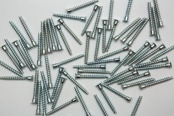 Mound of furniture screws top view on white background