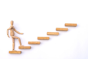 Ascending stairs and wooden man model going upward, isolated on white background.Business growth,...