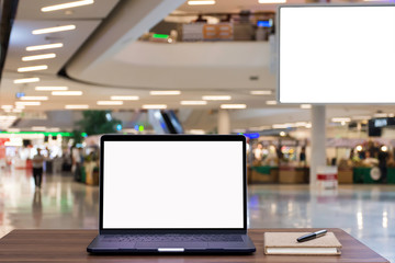 Female hand holding and using mobile smartphone with blank white screen with boutique shop in shopping mall center blurred background.