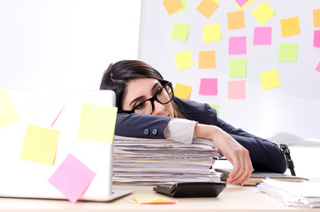 Young female employee in conflicting priorities concept 