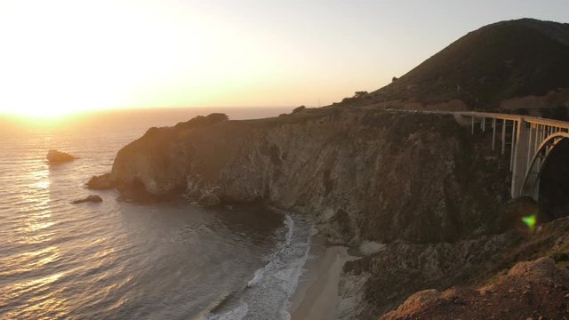Panning shot of sunset from Cabrillo Highway 1 over Bixby Creek Bridge at Big Sur, California, USA