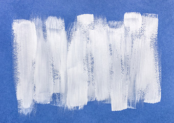 white acrylic brush strokes on blue textured paper