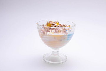 tasty homemade dessert in a sundae with colorful ice cream, fruit, chocolate chips on a white background for children and adults.