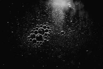 Naklejka premium Air bubbles in the water background.Abstract oxygen bubbles in the sea.Water bubbles isolate on black background.Black and white tone style.
