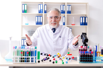 Old male chemist working in the lab 