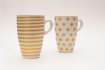 Two cups of coffee stand together. Cups for coffee with a pattern in the form of circles and stripes on a white background. Layout, copy space.