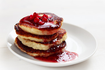 Stack of pancakes with maple syrup and berries