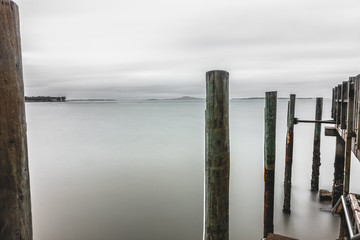 Coastal pier poles cloudy day