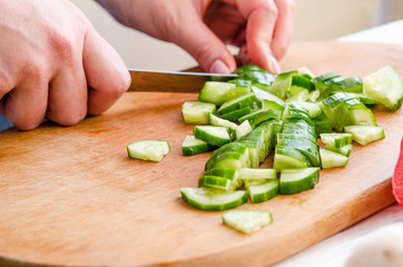 Woman hands cutting vegetables on wooden background