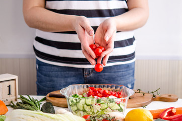 Woman hands adding vegetables to dishes
