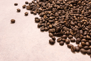 Roasted coffee beans in bulk on a light pink background. dark cofee roasted grain flavor aroma cafe, natural coffe shop background, top view from above, copy space