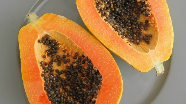 Top view of ripe half cut papaya, flat lay. Rotate