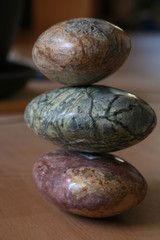 Fototapeta na wymiar Steine in magenta, rot, grün und brauner Farbe mit verschiedenen Strukturen aufeinander liegend gestapelt 