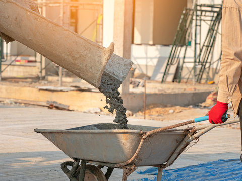 Concrete mixed cement pouring from mortar grinder truck to trolley in construction site