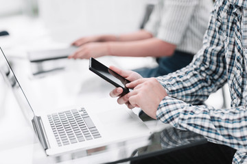 Fototapeta premium close up.business man with a smartphone sitting at his Desk