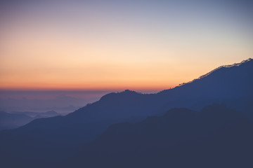 Bright stunning amazing sunset dawn in the mountains of Sri Lanka, the sun rises from behind the mountains. Beautiful minimalistic landscape