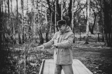 Mature man in parka jacket and hat walk at countryside 