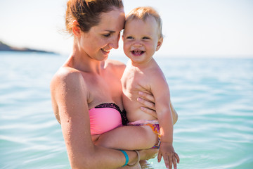 Summer vacation on the sea beach. Mom with the baby in the water..