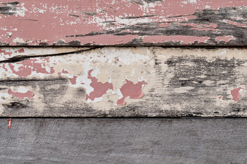 Chipped red, cream, and white paint on weathered boards