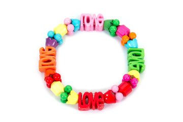 Colorful plastic bracelet isolated on white background. Colorful children bracelet with love letter and beads isolated