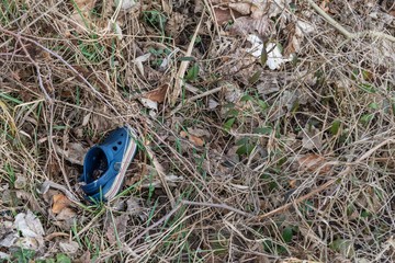 Einzelne blaue Kinder Sandale weggeworfen in hohem Gras, Deutschland