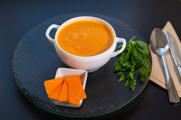 Bowl of healthy butternut soup with herbs