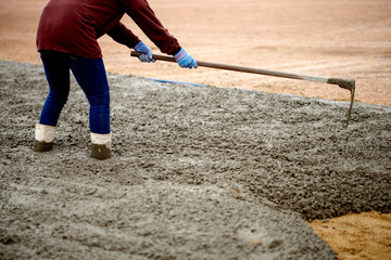 Workers are building a large concrete yard.