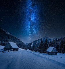 Milky way over small cottages in winter Tatra mountains, Poland