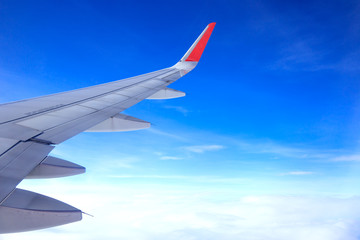 airplane wing with many clouds in the sky