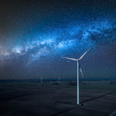 Milky way over wind turbines as alternative energy at night