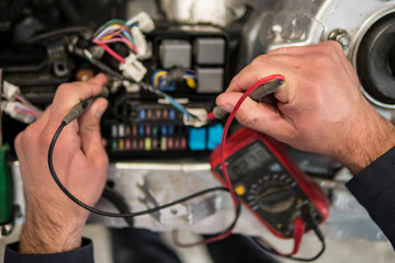 car electrician repairs car, tester and fuses and nippers