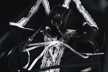 Leather black whip and handcuffs for domination and hard sex