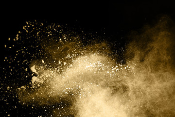 Golden powder explosion on black background. Freeze motion. - obrazy, fototapety, plakaty
