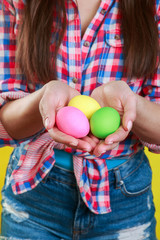 Fototapeta na wymiar Hands holding colorful painted easter eggs. Easter concept