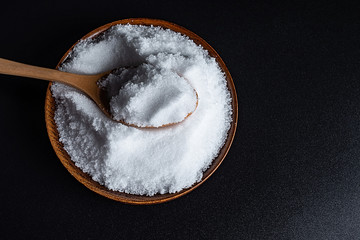 a spoonful of fine salt on a black background