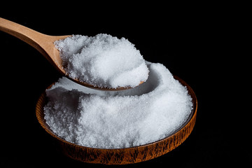 a spoonful of fine salt on a black background