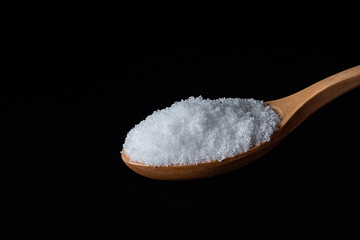 a spoonful of fine salt on a black background