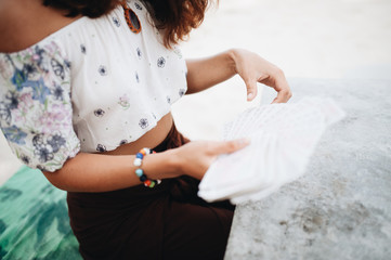 Woman is reading Tarot cards at the beach