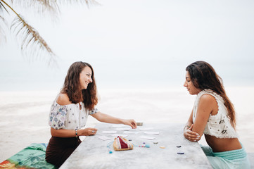 Woman is reading Tarot cards at the beach