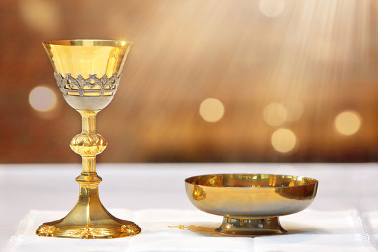 Golden chalice on the altar and rays of light from heaven