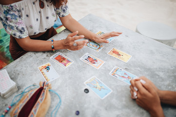 Woman is reading Tarot cards at the beach
