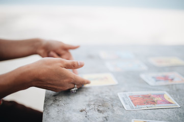 Woman is reading Tarot cards at the beach