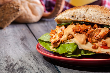 Fried chicken meat with cheese and vegetables in bun